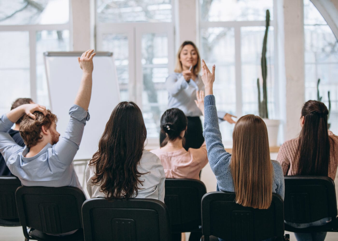 Increase. Female speaker giving presentation in hall at university workshop. Audience or conference hall. Rear view of unrecognized participants. Scientific, business event, training. Education